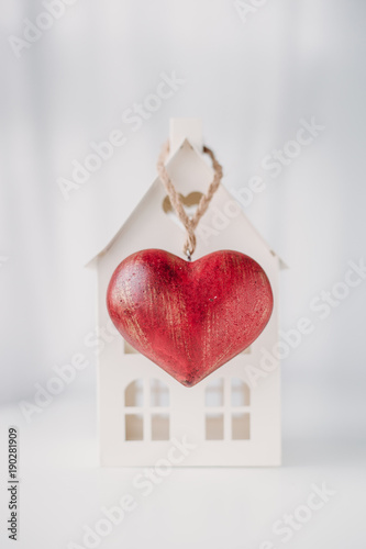 Home and red heart on white background.  concept for St. Valentine's Day and sale of houses