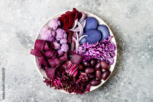 Purple Buddha bowl with spiral carrots, cauliflower, beet, onion, potato, shredded red cabbage, radicchio salad, kalamata olives. Vegan detox veggie bowl
