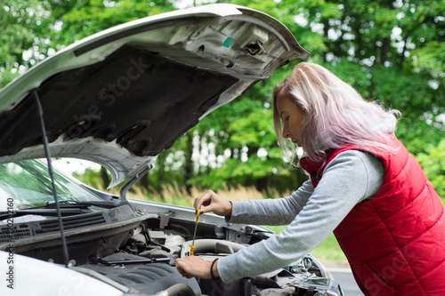Girl checks the oil in the car's engine © dima
