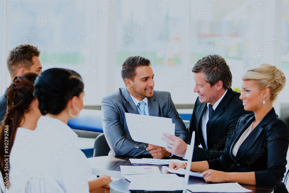 Image of business partners discussing documents and ideas at meeting. Image of business partners discussing documents and ideas at meeting.