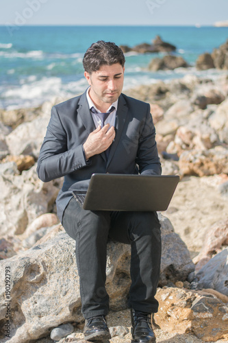 Freelancer employe businessman working on the sea while on vacation.