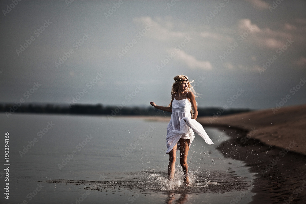 cheerful young girl running through water with splashes