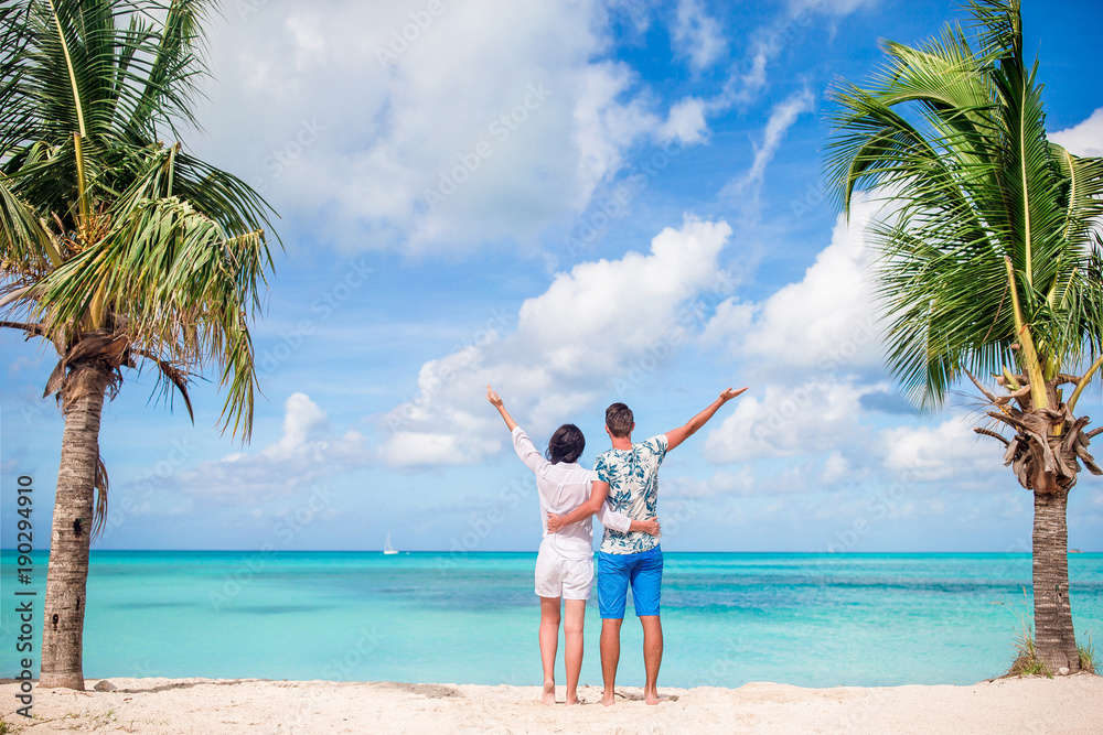 Young couple on white beach. Happy family on honeymoon vacation Young couple on white beach. Happy family on honeymoon vacation