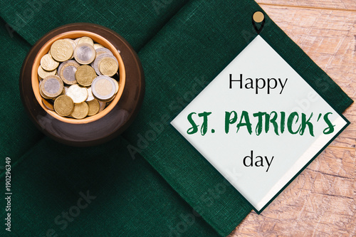Beautiful green and wooden background for Saint Patrick's day celebration. Leprechaun pot of gold. Great party at the 17th March. Patric's postcard design. Horseshoe as a symbol of the holiday.