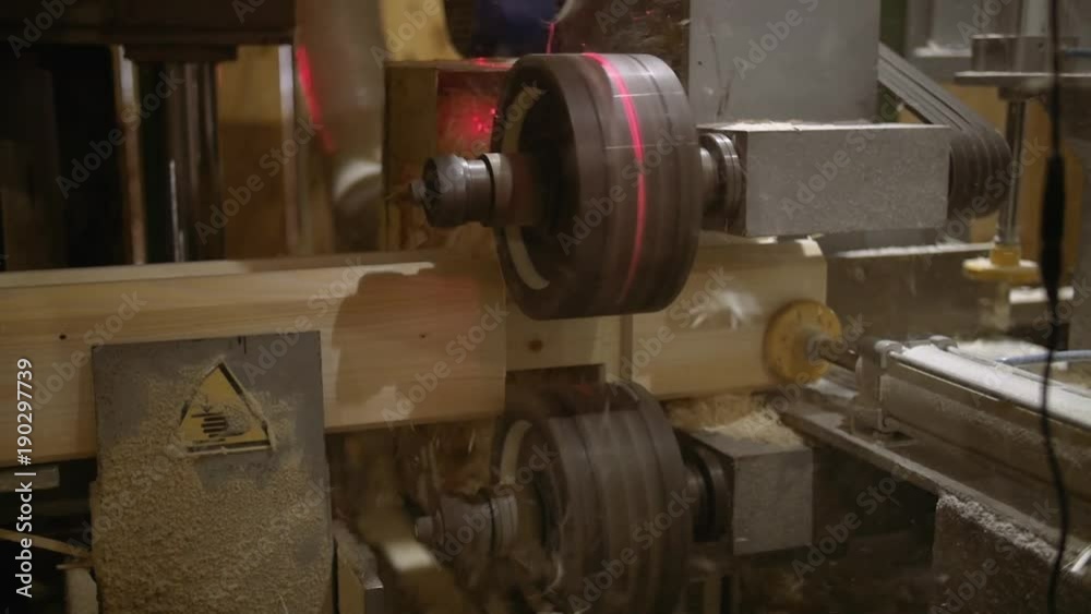 Carpenter machine with laser pointer makes precise chute on lumber block at sawmill facility, lots of sawdust, close up Carpenter machine with laser pointer makes precise chute on lumber block at sawmill facility, lots of sawdust, close up
