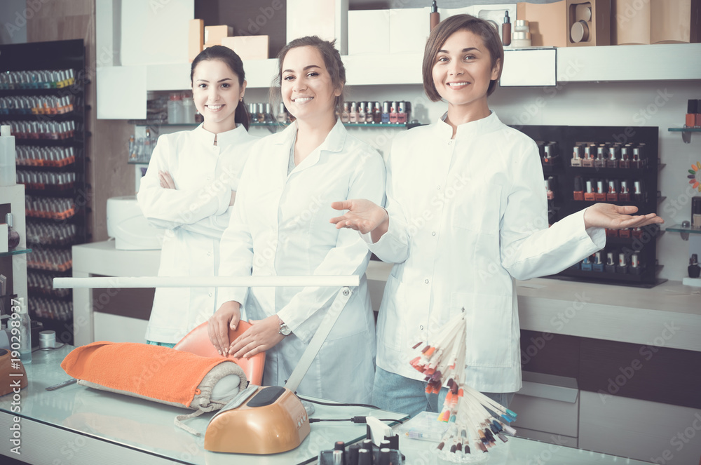 Obraz premium Portrait of professional manicurists at working place inviting to salon