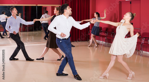 Positive group people dancing lindy hop in pairs