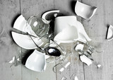 Glass broken dishes crashed wine glass tea cups sauser spoon with fragments on modern rustic wood