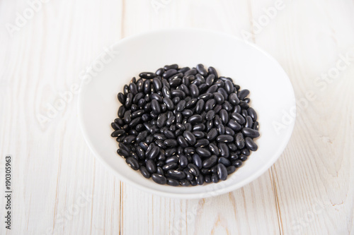 black kidney beans in the white plate.wooden background.
