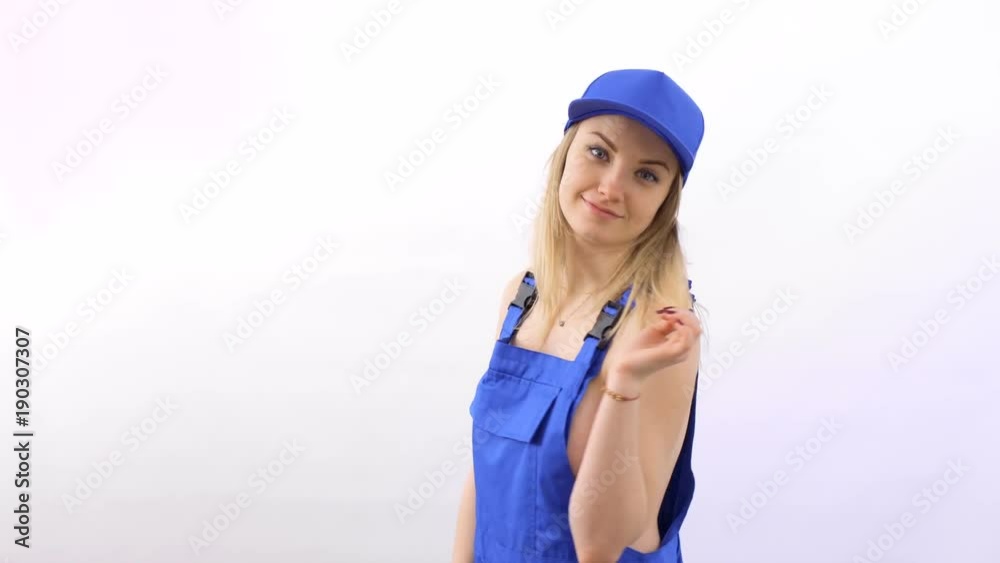 Beautiful playful girl in blue overalls poses for camera at white background Beautiful playful girl in blue overalls poses for camera at white background