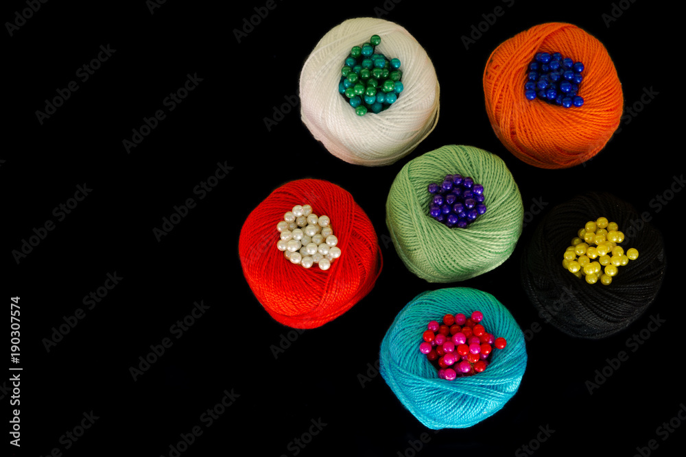 Colorful wool balls on a black background.