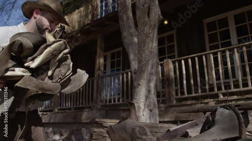 Wallpaper Mural Cowboy man taking saddle off of wagon Torontodigital.ca