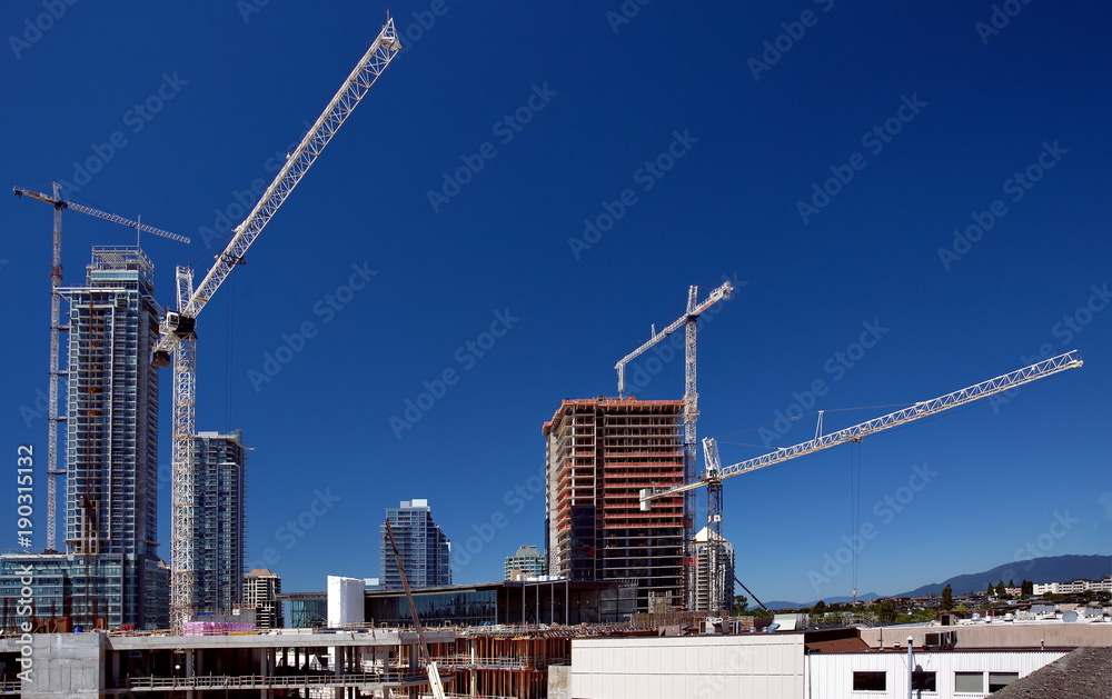
Construction of a new district of high-rise buildings. Four construction cranes at the site and three high-rise buildings under construction.
