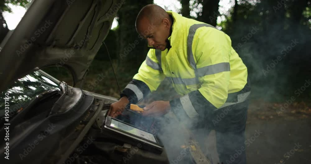 4k, Young roadside mechanic fixing a broken down car. Slow motion. 4k, Young roadside mechanic fixing a broken down car. Slow motion.