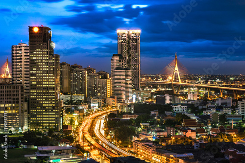 Top View of City Elevated Highway and Bangkok Cityscape with Bhumibol Bridge. Skyscraper with Car Traffic Light Trial at Night Time  Thailand