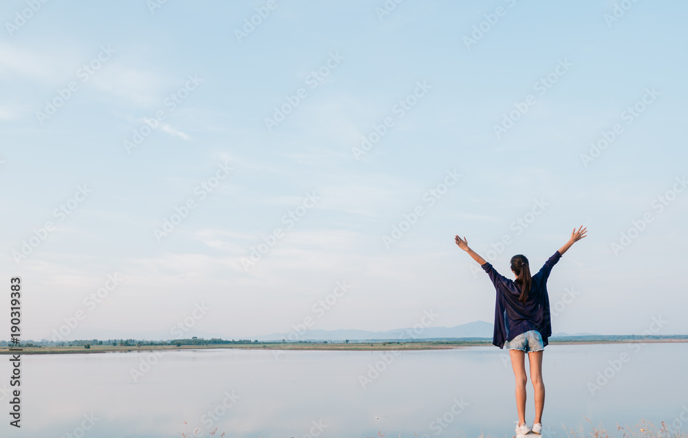 Girl standing against the blue sky, Freedom concept Girl standing against the blue sky, Freedom concept