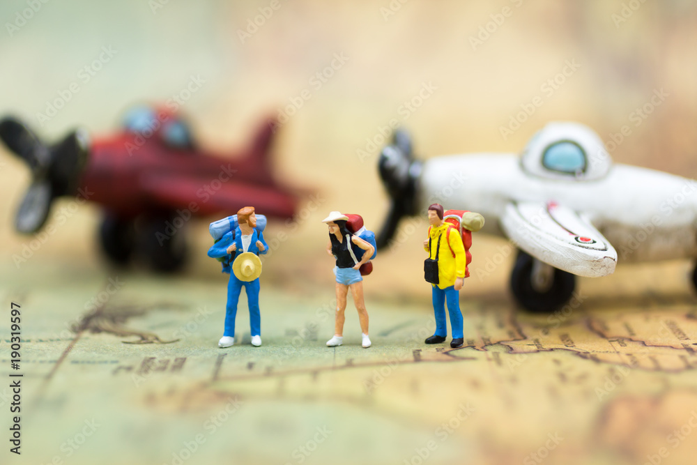 Miniature people: travelers with backpack standing on world map travel by plane. Image use for travel business concept.
