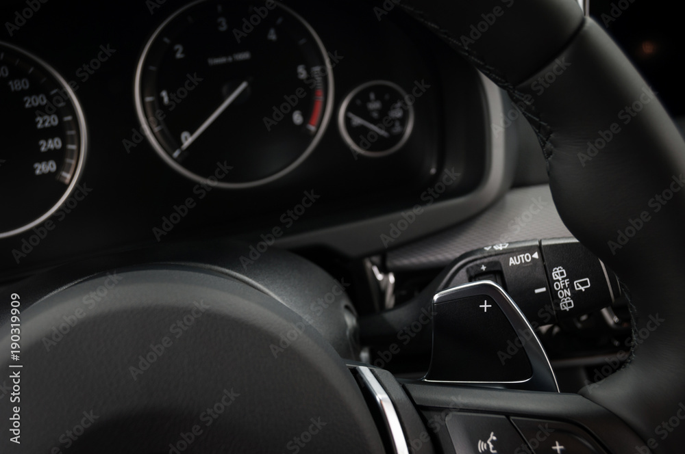 Manual gear changing stick on a car's steering wheel, Modern car interior details.