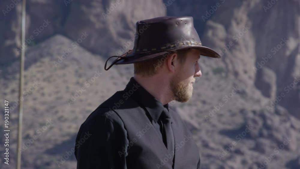 Cowboy waving person past in front of mountains friendly man Cowboy waving person past in front of mountains friendly man