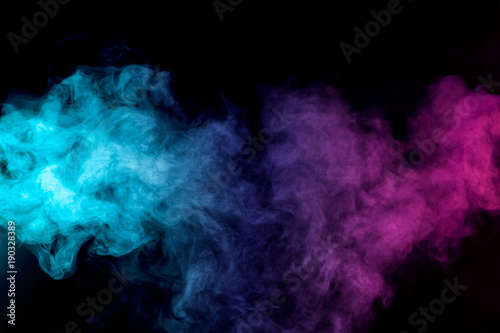 Dense multicolored smoke of   red, purple and pink colors on a black isolated background. Background of smoke vape photo
