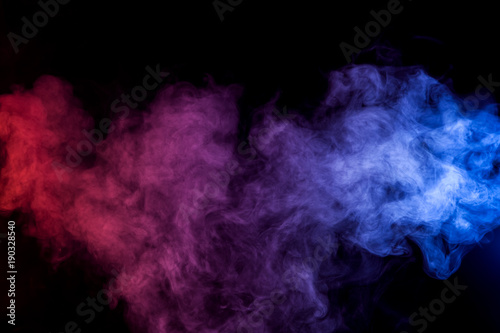 Dense multicolored smoke of red and blue colors on a black isolated background. Background of smoke vape