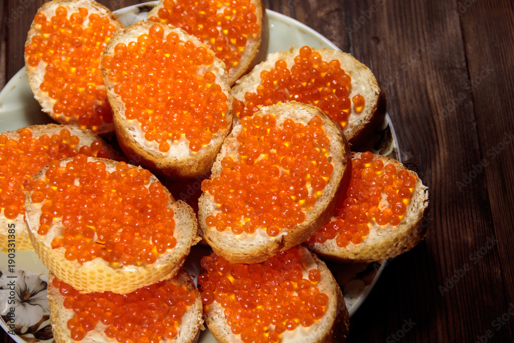 Sandwiches with butter and red caviar on wooden table Sandwiches with butter and red caviar on wooden table
