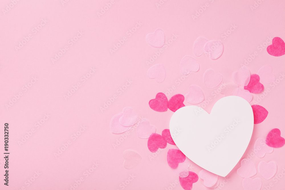 White wooden heart and paper hearts on pink pastel background top view. Greeting card for Valentines, Woman or Mothers Day. Wedding mockup. Flat lay.