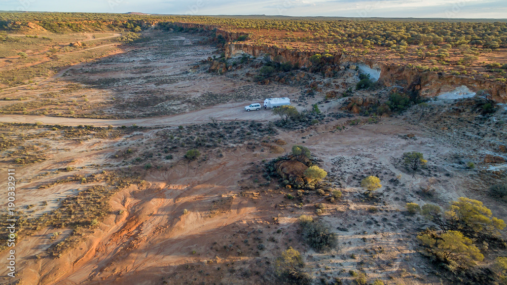 Aerial view of four wheel drive vehicle and caravan camped in the outback of Australia
