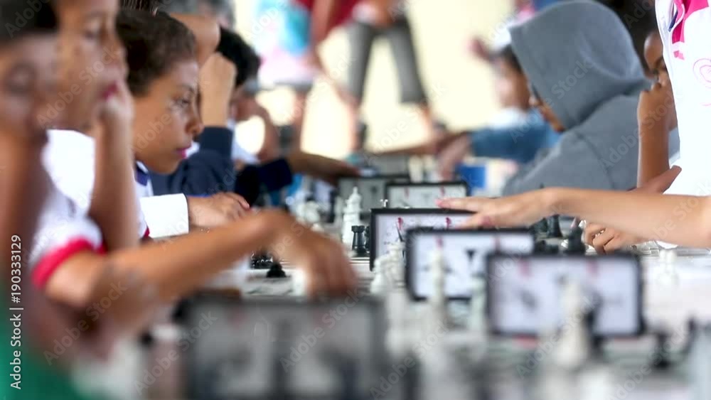 Kids sit at tables playing chess Kids sit at tables playing chess