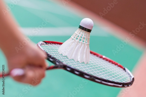kid holding badminton racket and shuttlecock in badminton court