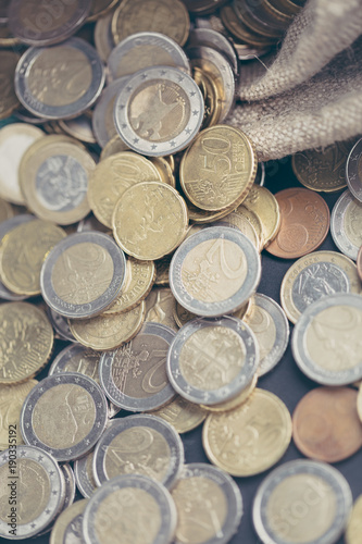 Euro coins scattered from the bag. The concept of saving money. Shallow depth of field.