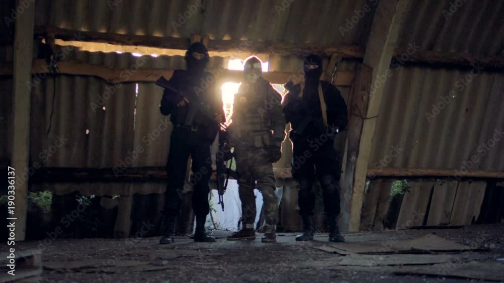 A SWAT team rests with their automatic rifles in hands. A SWAT team rests with their automatic rifles in hands.