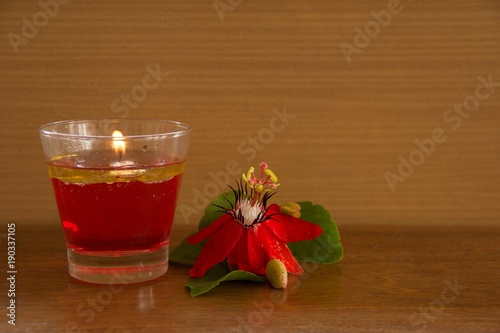 Water Candle in Glass and Red Passion Flower /The beauty of water candles in glass and red flowers on wooden floors and the backdrop. photo