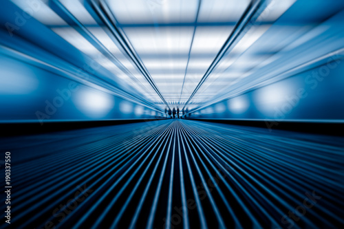 blurred motion of airport moving walkway, blue toned