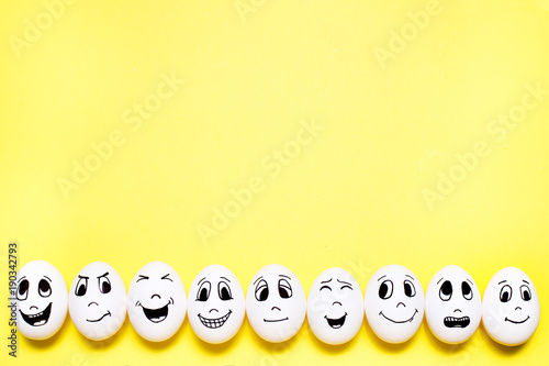 Eggs with drawn cartoon faces with various emotions with copyspace