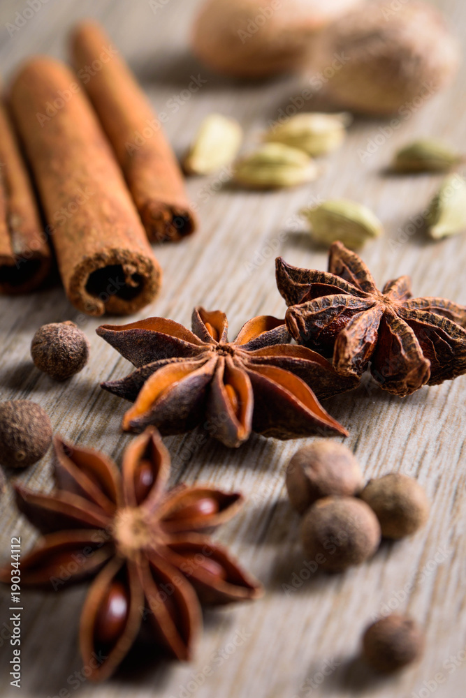 Various Spices background. Cinnamon sticks and anise stars close-up on wood background Various Spices background. Cinnamon sticks and anise stars close-up on wood background