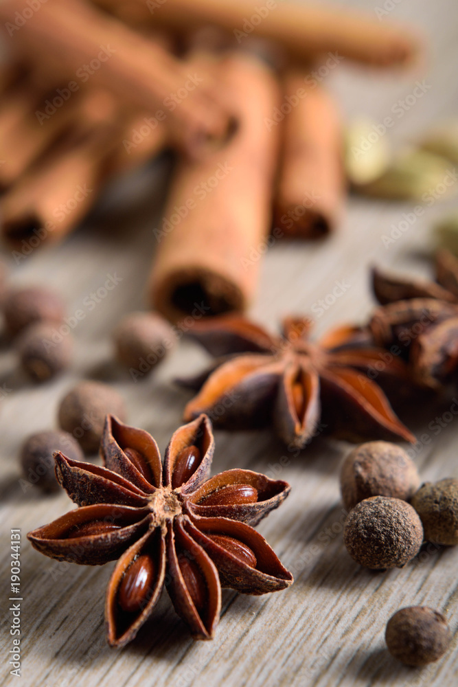 Various Spices background. Cinnamon sticks and anise stars close-up on wood background Various Spices background. Cinnamon sticks and anise stars close-up on wood background