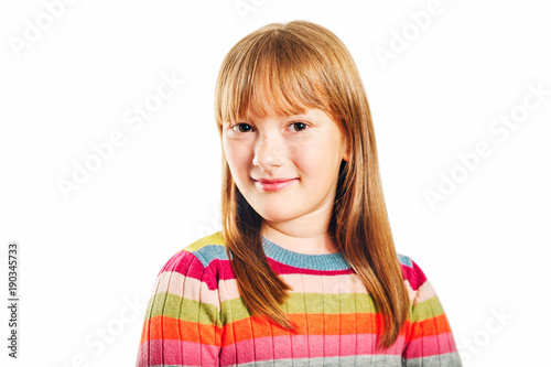 Studio shot of young little 9-10 year old girl, wearing colorful pullover, white background