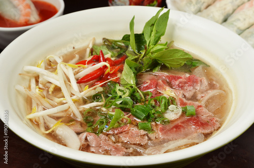 Traditional Vietnamese beef soup pho on a wooden table 