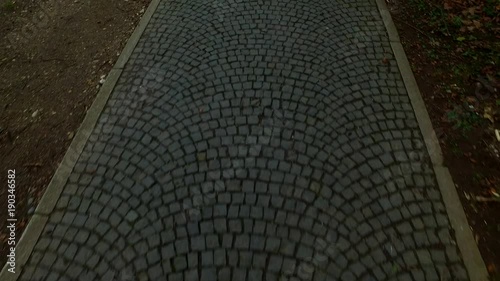 Walking on granite pavement. Grungy. Old. On the street.