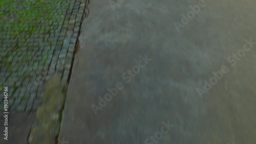 Walking on granite pavement. Grungy. Old. On the street.