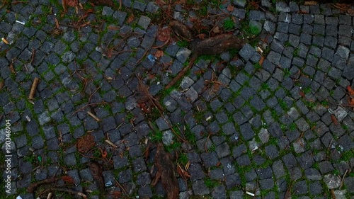 Walking on granite pavement. Grungy. Old. On the street.