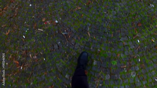 Walking on granite pavement. Grungy. Old. On the street.