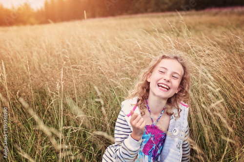 adorable little girl hugs in the meadow and smiles sincerely