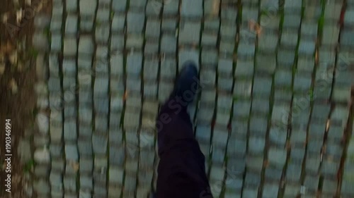 Walking on granite pavement. Grungy. Old. On the street.