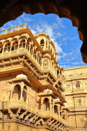 The architectural details of Jaisalmer fort palace (viewed through an arcade) in Jaisalmer, Rajasthan, India photo