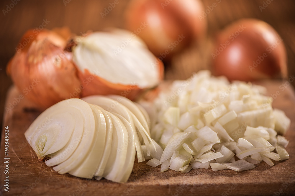 close up of chopped, sliced, halved and whole onion on wood table close up of chopped, sliced, halved and whole onion on wood table