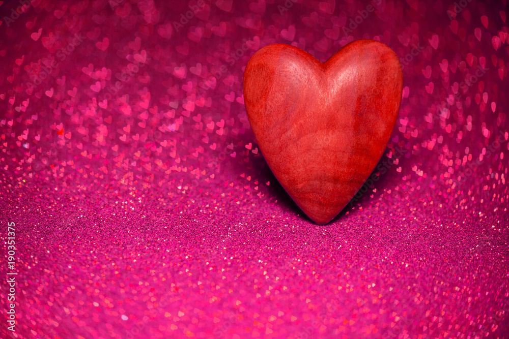 Wooden red heart on a red blurred background