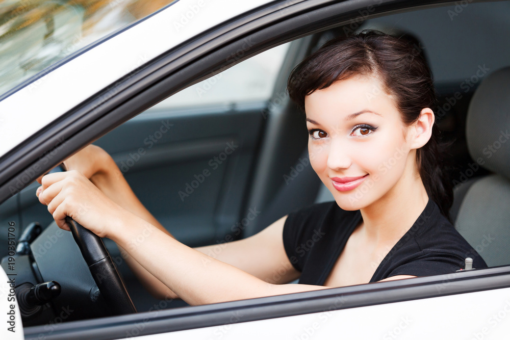 Pretty woman driver smiling to you from the white car