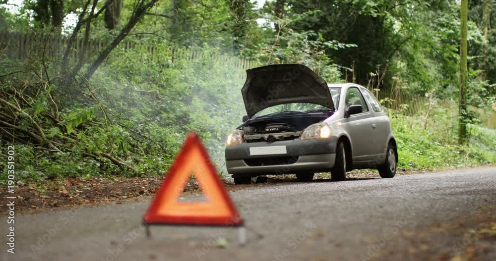 4K Broken down car with smoking engine left abandoned on quiet country road. No people.
